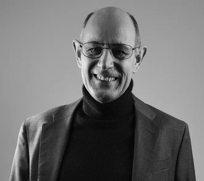 Portrait en noir et blanc de Stephen William Rowe, auteur-compositeur anglais installé près de Grenoble, souriant, en col roulé et veste